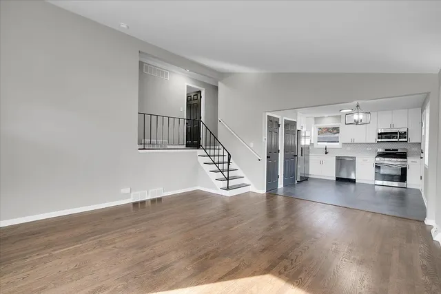 a view of a kitchen with wooden floor and electronic appliances