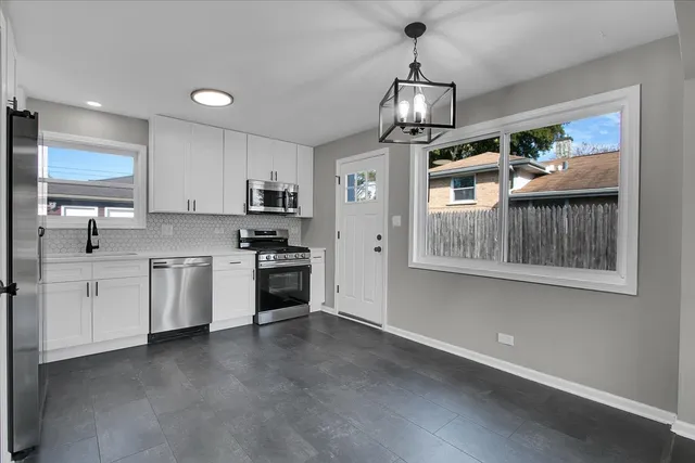 a kitchen with stainless steel appliances granite countertop a stove refrigerator and cabinets