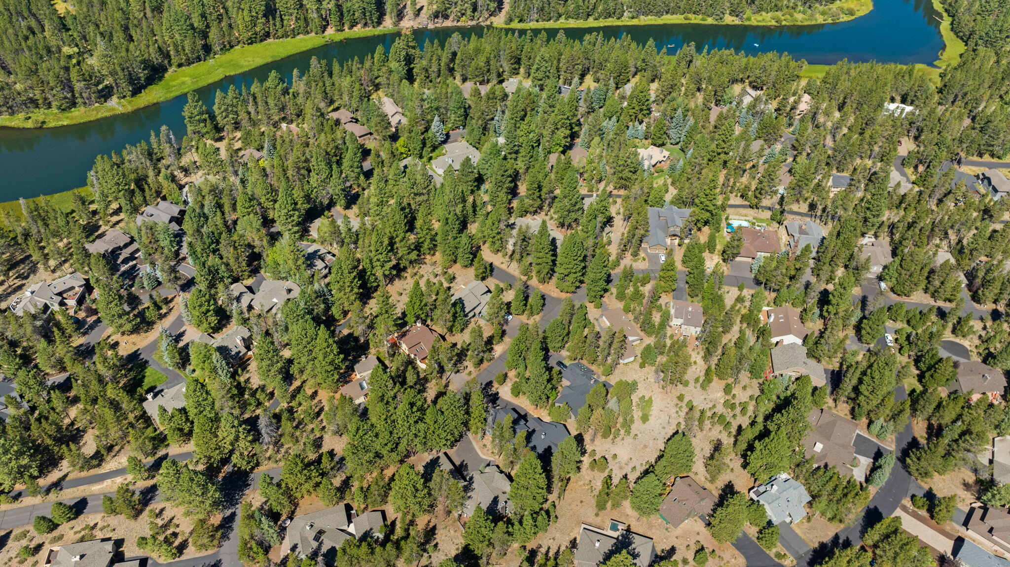 58026 Kinglet Road Sunriver, OR 97707 - Photo 38 of 39 a view of a lake with a green field with wooden floor