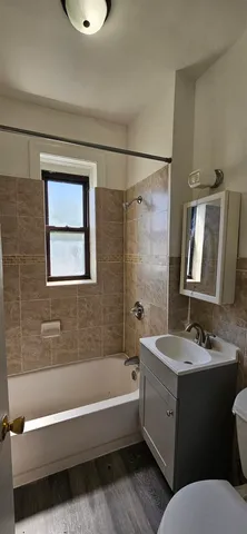 a bathroom with a tub sink and mirror