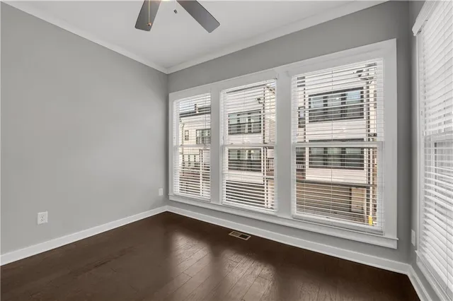 a view of an empty room with a window and wooden floor