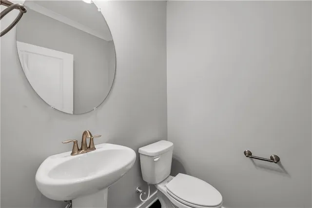 a bathroom with a toilet a sink and mirror