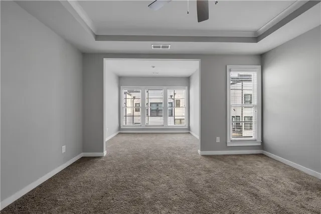 a view of a big room with windows and chandelier fan