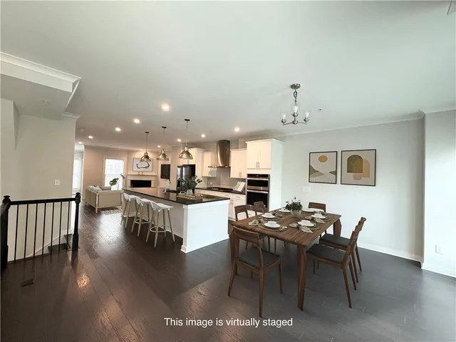 a kitchen with stainless steel appliances kitchen island granite countertop a stove a sink a dining table and chairs