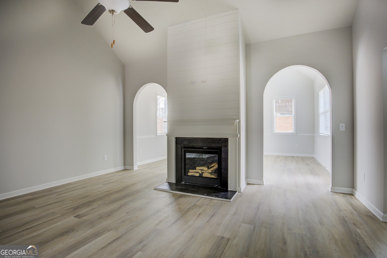 1007 Towne Circle Social Circle, GA 30025 - Photo 12 of 48 an empty room with wooden floor a fireplace and windows