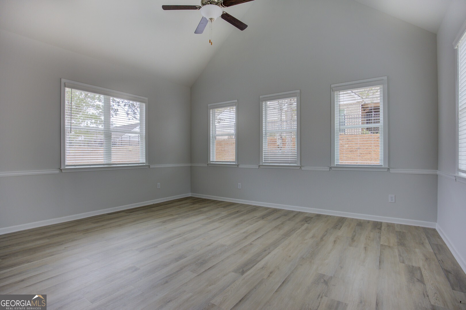 1007 Towne Circle Social Circle, GA 30025 - Photo 17 of 48 a view of an empty room with wooden floor and a window