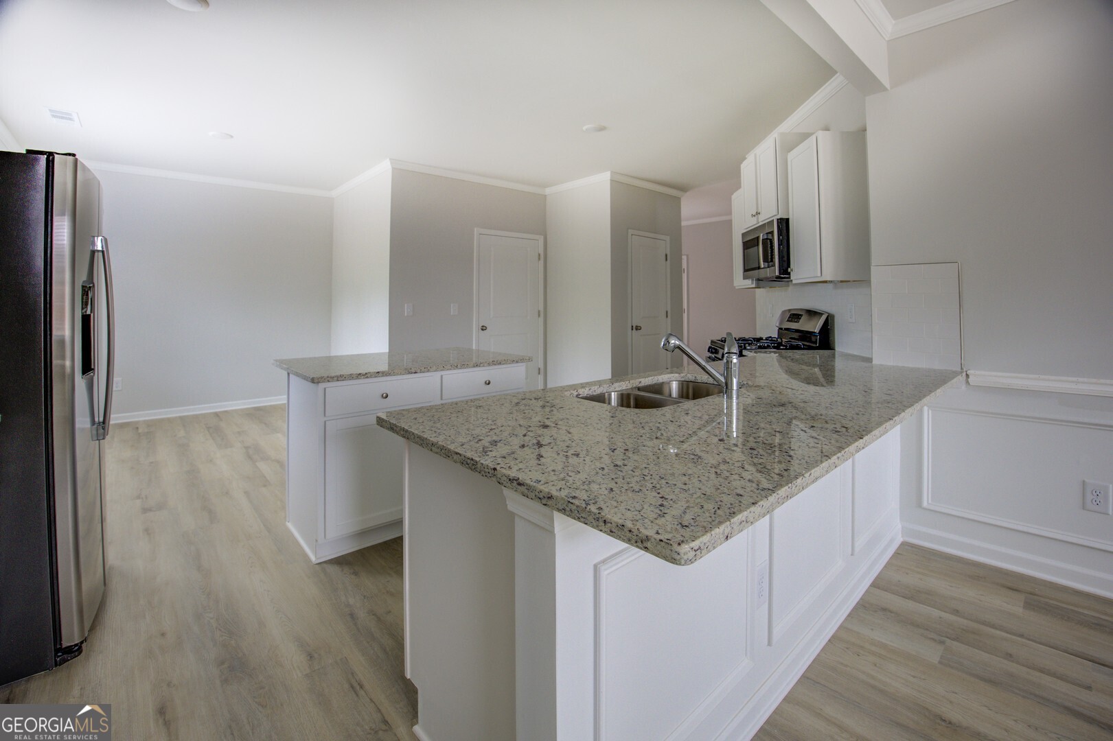 1007 Towne Circle Social Circle, GA 30025 - Photo 22 of 48 a kitchen with stainless steel appliances granite countertop a sink and a refrigerator