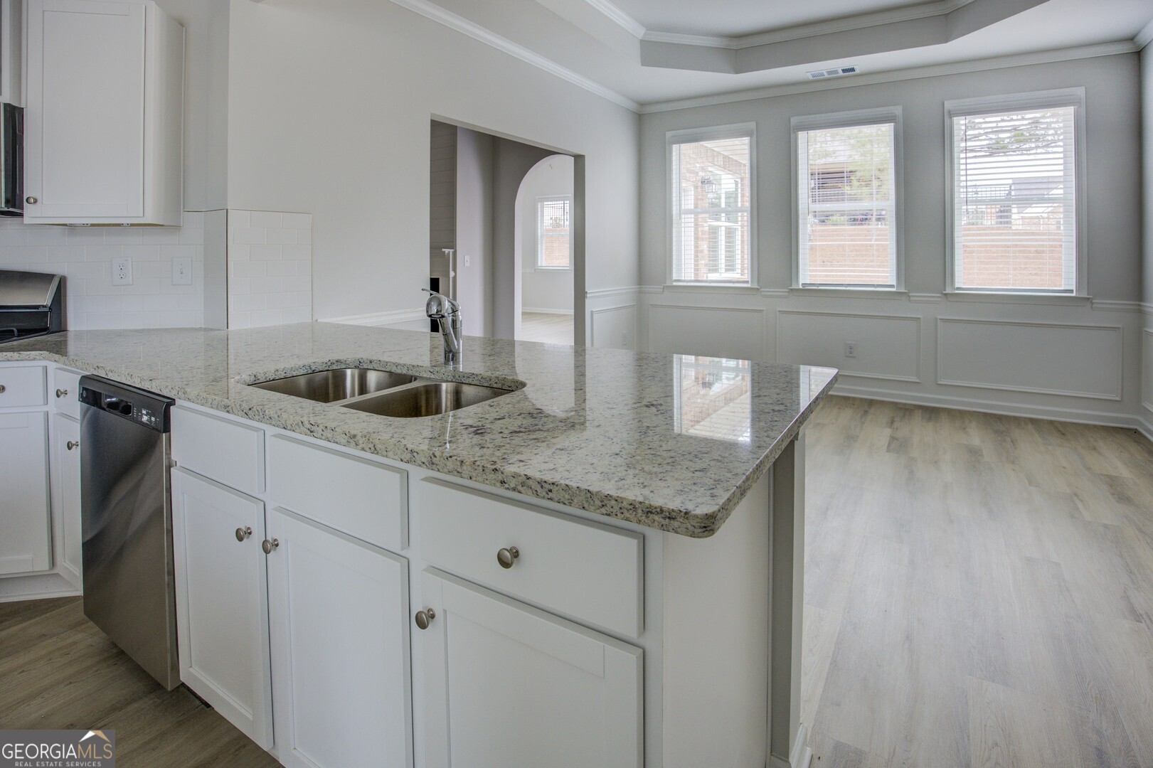 1007 Towne Circle Social Circle, GA 30025 - Photo 24 of 48 a kitchen with granite countertop a sink and dishwasher cabinets with wooden floor