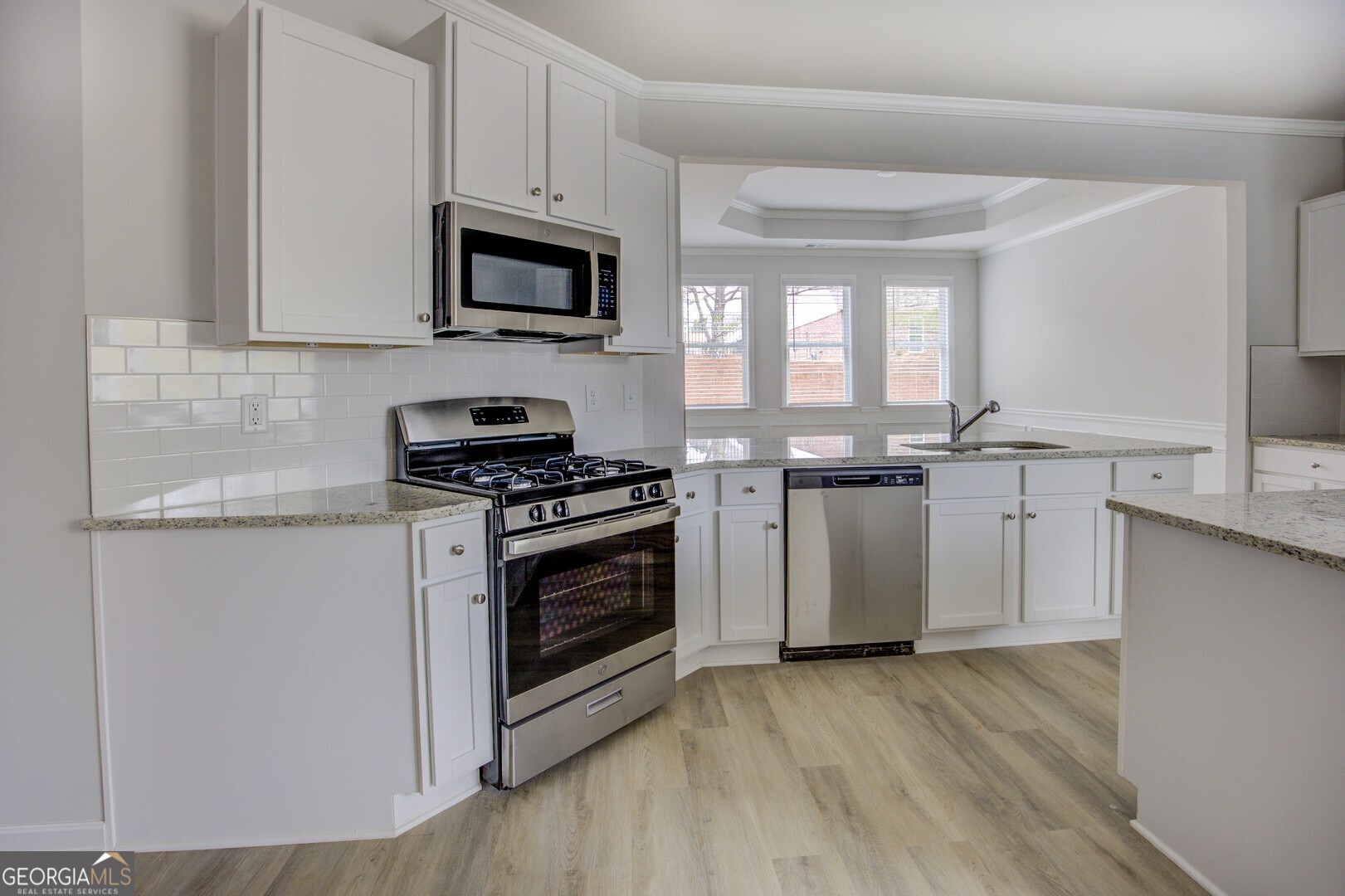 1007 Towne Circle Social Circle, GA 30025 - Photo 26 of 48 a kitchen with granite countertop a stove and a microwave