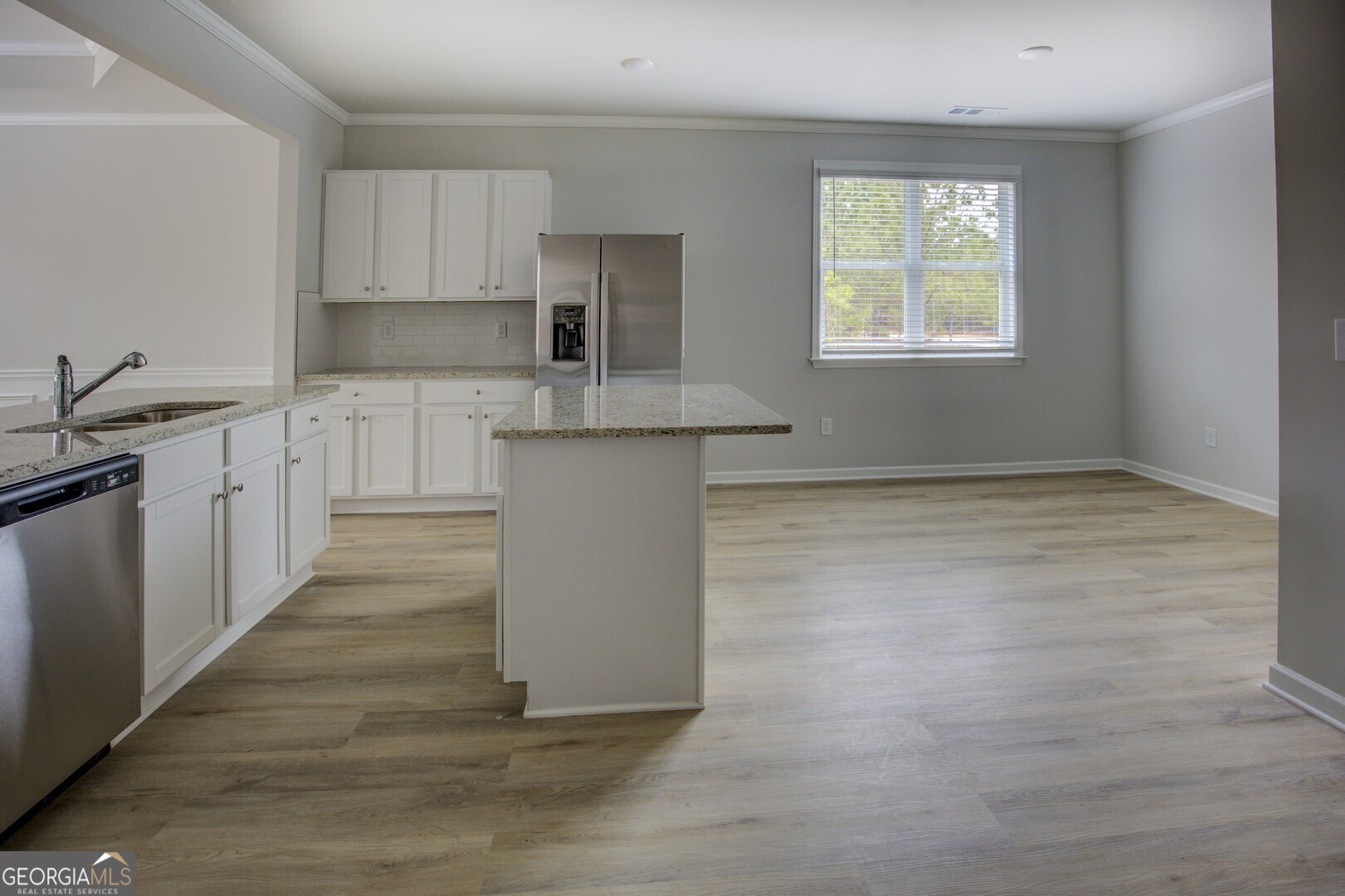 1007 Towne Circle Social Circle, GA 30025 - Photo 27 of 48 a kitchen with kitchen island a sink wooden floor and a stove