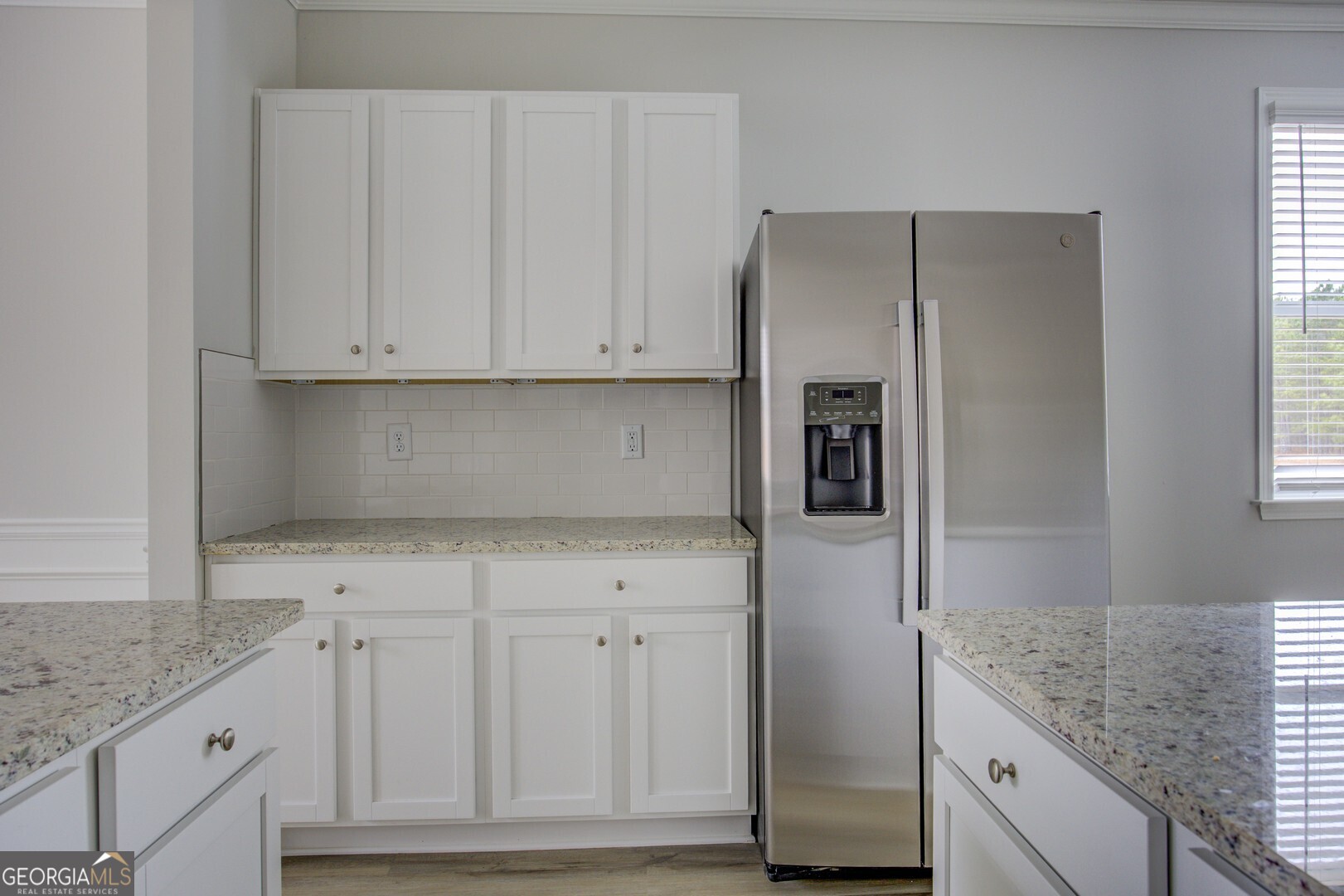 1007 Towne Circle Social Circle, GA 30025 - Photo 28 of 48 a kitchen with granite countertop white cabinets and refrigerator