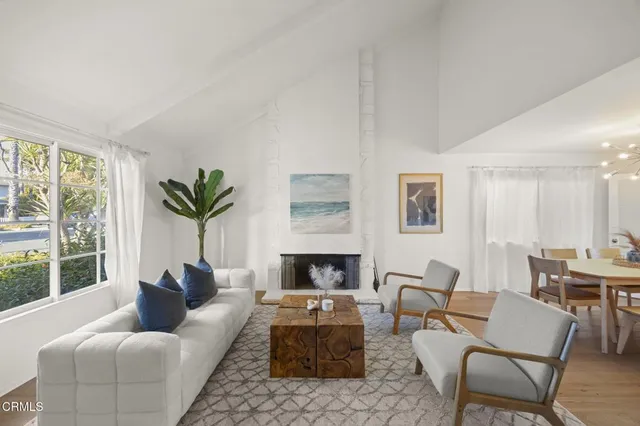 a living room with furniture fireplace and a large window