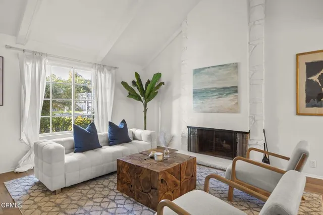 a living room with furniture a large window and a fireplace