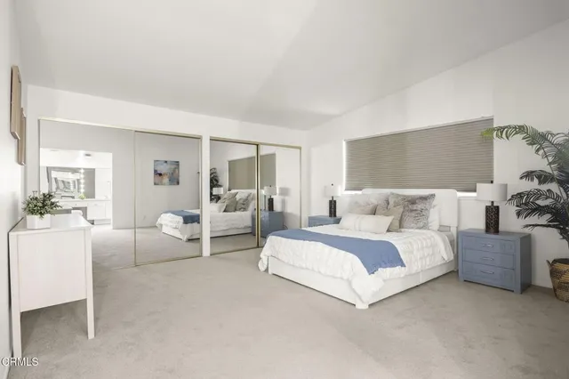 a bedroom with bed and white cabinets