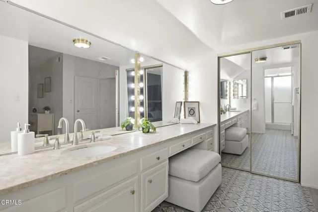 a bathroom with a granite countertop sink and a mirror
