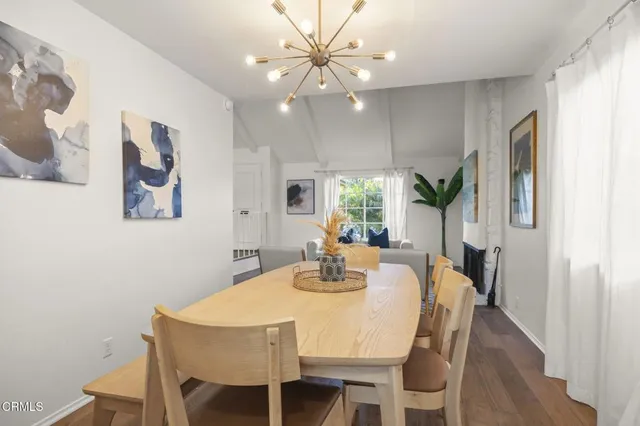 a view of a dining room with furniture and a chandelier fan