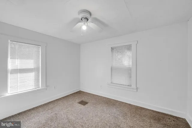 an empty room with windows and closet