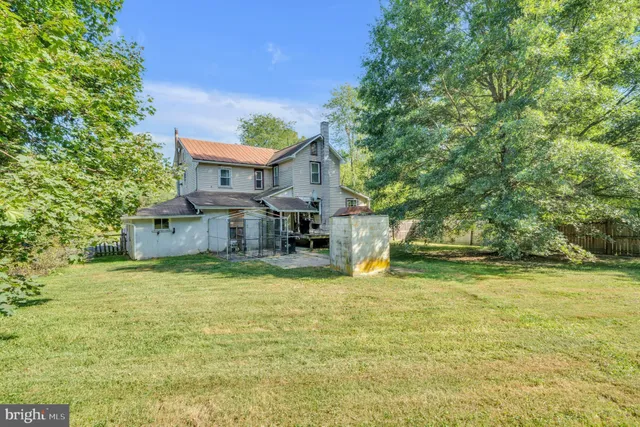 a view of a house with a yard balcony and a tree
