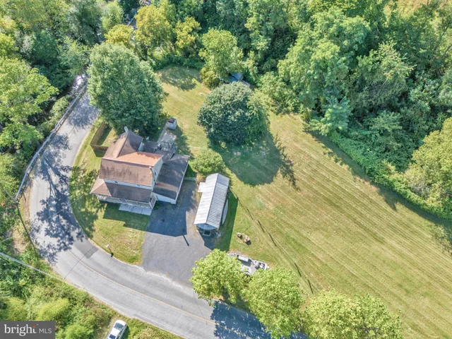 an aerial view of a house with swimming pool and garden
