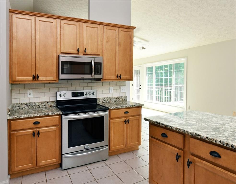 795 Sunset Ridge Lane Southeast Lawrenceville, GA 30045 - Photo 12 of 57 a kitchen with granite countertop cabinets stainless steel appliances and a sink