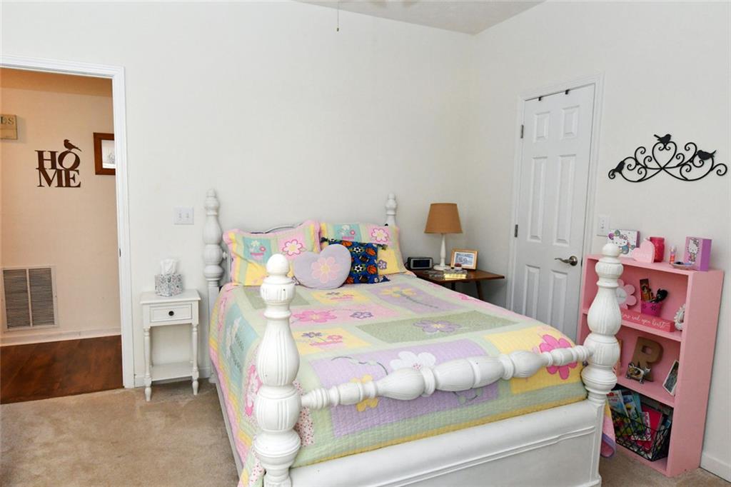 795 Sunset Ridge Lane Southeast Lawrenceville, GA 30045 - Photo 47 of 57 a bedroom with a bed and wooden floor