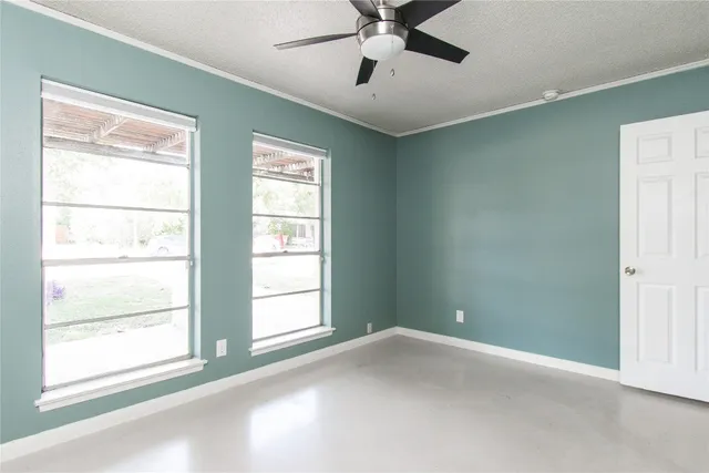 a view of empty room with window and ceiling fan