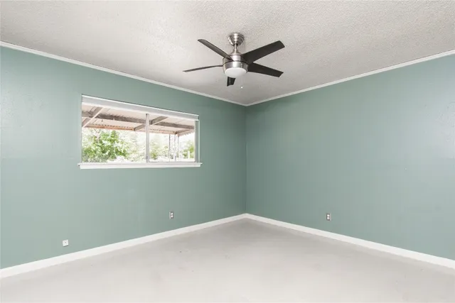 an empty room with a window and a ceiling fan