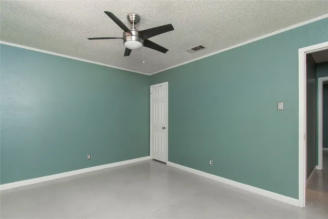 an empty room with a ceiling fan and a window