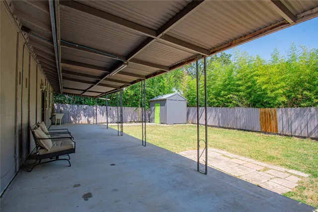 a view of a backyard with wooden floor and fence