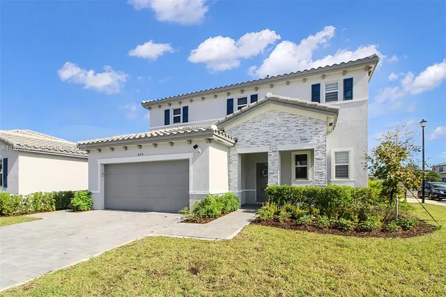 a front view of a house with a yard and garage