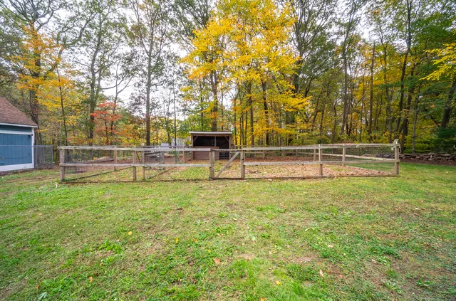an empty room with wooden floor fireplace and windows