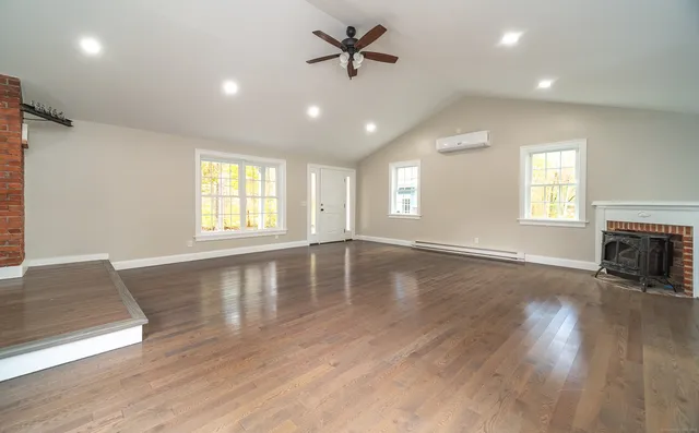 a view of an empty room with a window and wooden floor