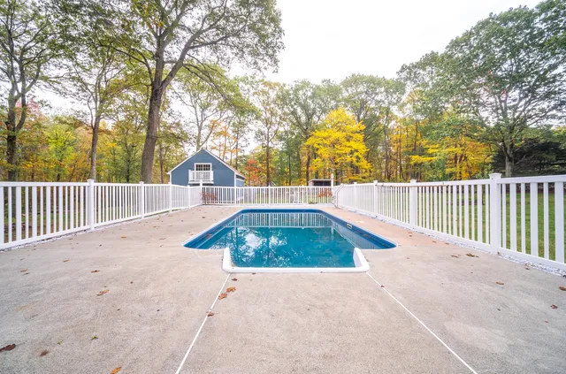 a view of a swimming pool with a patio and a yard