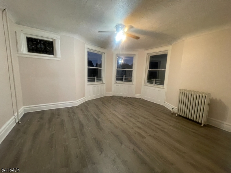 43 Mapes Avenue, Unit 2L Newark, NJ 07112 - Photo 2 of 7 a view of empty room with wooden floor and fan