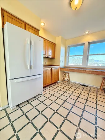 a kitchen with a sink a refrigerator and white cabinets