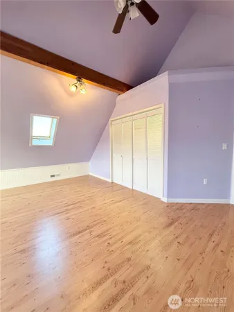 an empty room with a window and ceiling fan