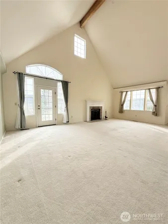 a view of an empty room with a fireplace and a window