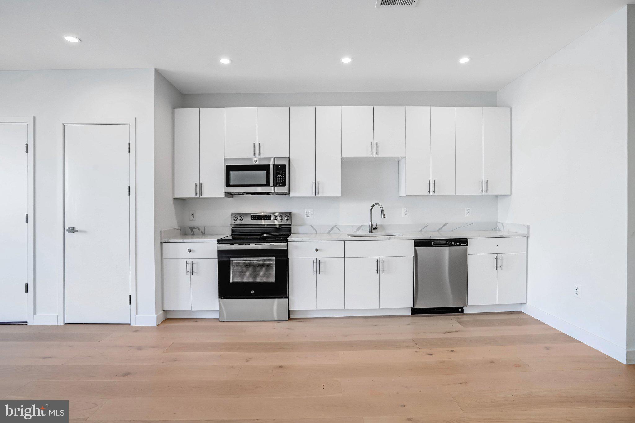 5221 F Street Southeast Washington, DC 20019 - Photo 13 of 63 a kitchen with granite countertop white cabinets and stainless steel appliances
