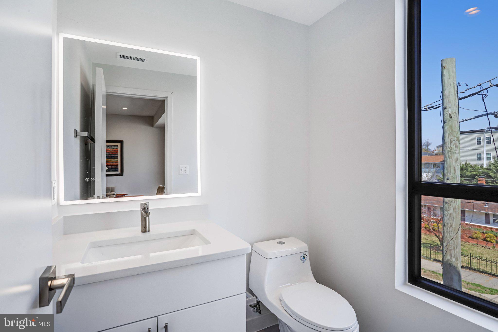 5221 F Street Southeast Washington, DC 20019 - Photo 44 of 63 a bathroom with a toilet a sink and mirror