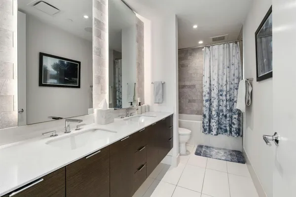 a bathroom with a double sink shower and a mirror