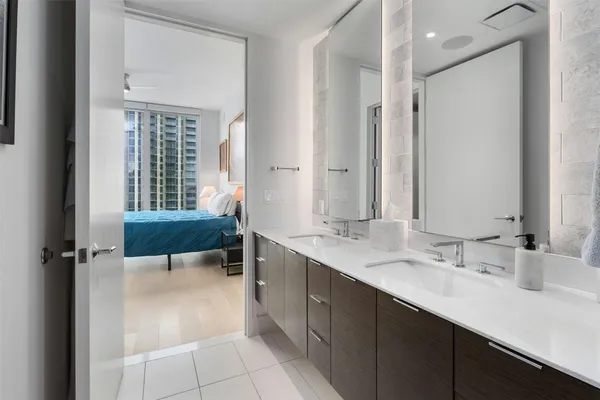 a bathroom with a double vanity sink a mirror and a bathtub