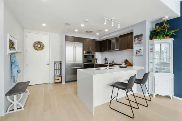 a kitchen with stainless steel appliances granite countertop a refrigerator and a stove top oven