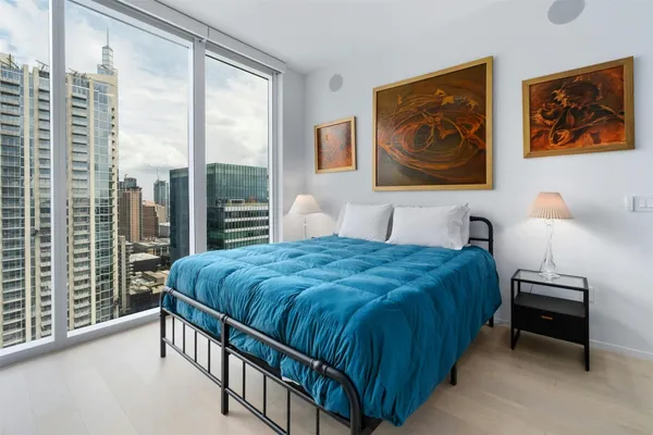 a bedroom with a bed and a painting on the wall