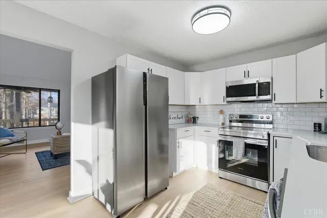 a kitchen with stainless steel appliances granite countertop a refrigerator and a stove top oven