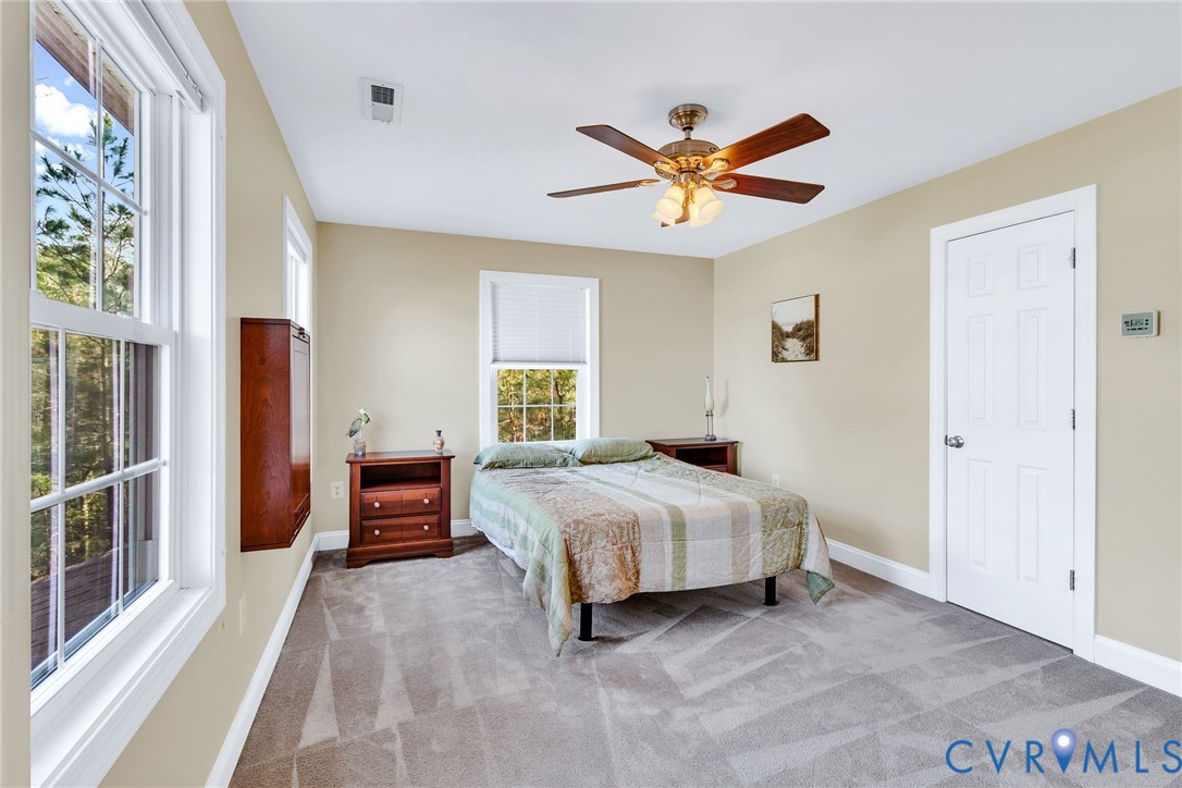 275 Granny's Bar Road Hague, VA 22469 - Photo 34 of 53 a bedroom with a bed and a chandelier