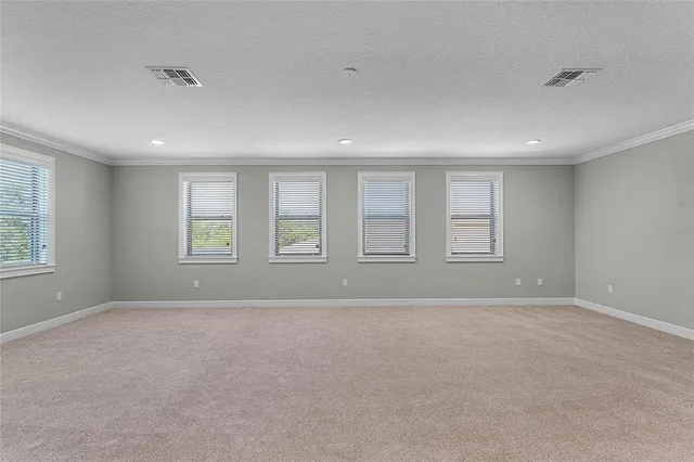 a view of an empty room and chandelier fan