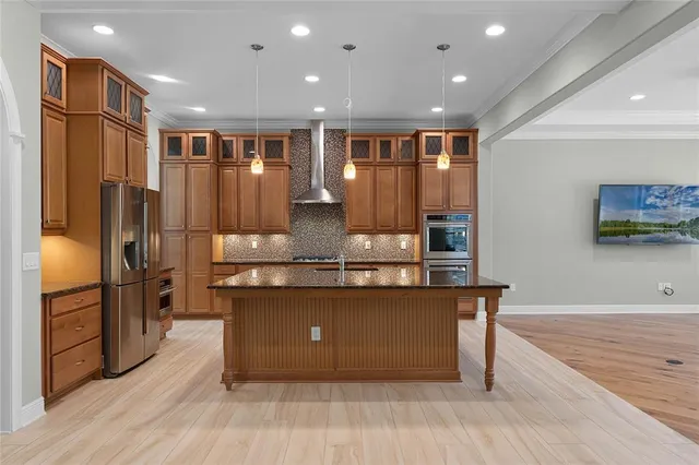 a large kitchen with stainless steel appliances granite countertop a large counter top and wooden floors