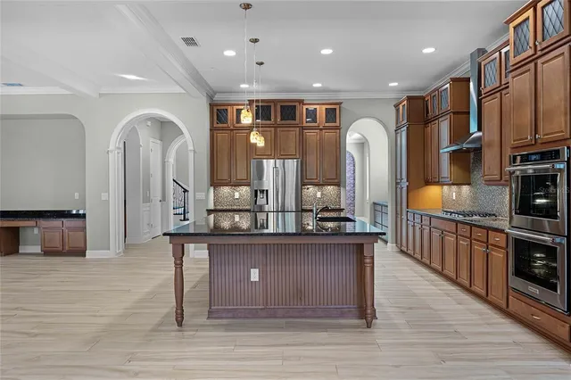 a kitchen with kitchen island granite countertop a stove and a sink