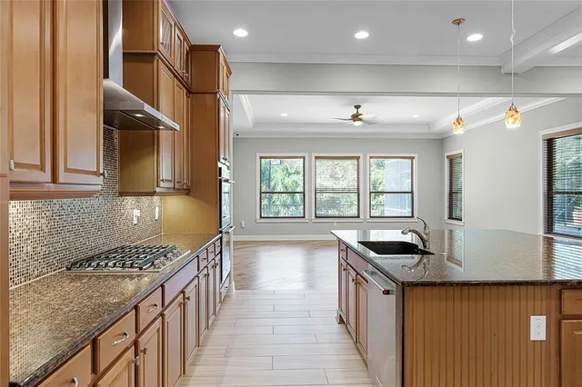 a kitchen with stainless steel appliances granite countertop a kitchen island a stove and a sink