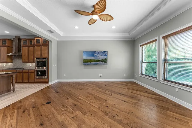a view of a livingroom with wooden floor and a ceiling fan